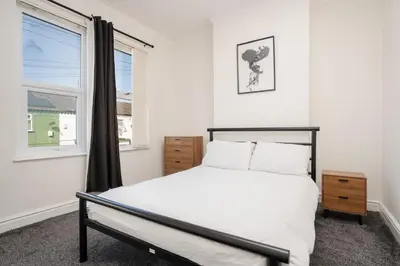 a bedroom with a large bed and a window at 10 Min to Beach Cheap Taxi to City FreeParking in Liverpool