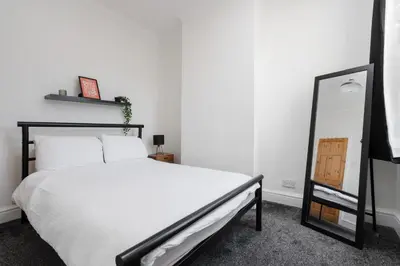 a bedroom with a white bed and a mirror at 10 Min to Beach Cheap Taxi to City FreeParking in Liverpool