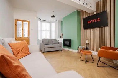 a living room with a white couch and a tv at 10 Min to Beach Cheap Taxi to City FreeParking in Liverpool
