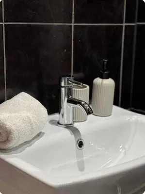 a bathroom sink with a towel and a faucet at Room 3 Shared House in L6 in Liverpool