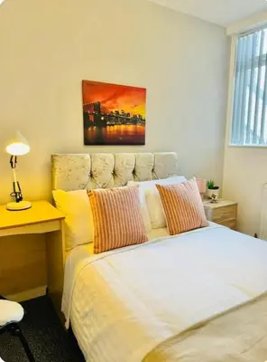 a bedroom with a bed with a desk and a painting on the wall at Room 3 Shared House in L6 in Liverpool