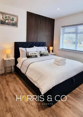 a bedroom with a large bed with two pillows on it at The Poulton Paradise in Poulton le Fylde