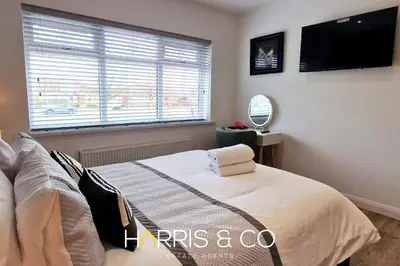 a bedroom with a bed and a flat screen tv at The Poulton Paradise in Poulton le Fylde