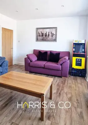 a living room with a purple couch and a table at The Poulton Paradise in Poulton le Fylde