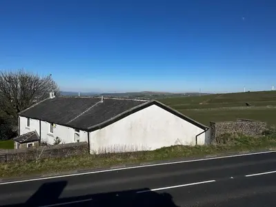 a white building on the side of a road at Cottage style flat in Oswaldtwistle