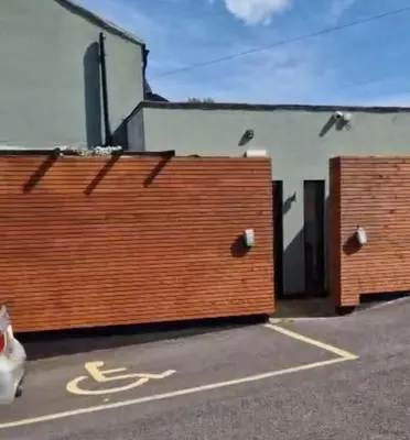 a pair of wooden gates in a parking lot at Cottage style flat in Oswaldtwistle