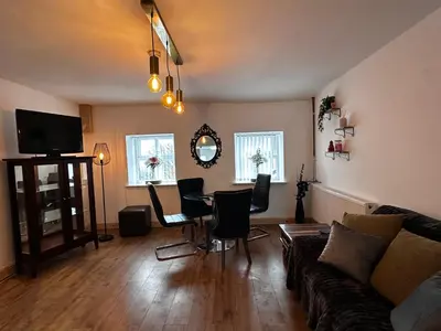 a living room with a couch and a table and chairs at Cottage style flat in Oswaldtwistle
