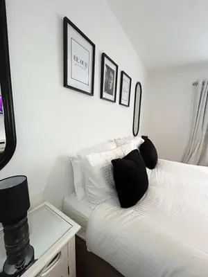 a bedroom with a white bed with black pillows at Lytham House Retreat - Free Parking in Marton