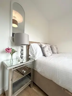 a bedroom with a bed and a table with a mirror at Lytham House Retreat - Free Parking in Marton