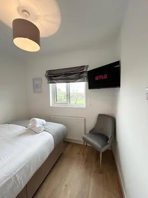 a bedroom with a bed and a chair and a window at Lytham House Retreat - Free Parking in Marton