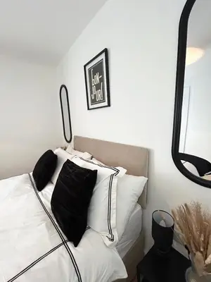 a bedroom with a bed with black and white pillows at Lytham House Retreat - Free Parking in Marton