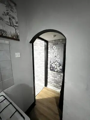a hallway with an open door to a brick wall at Cozy & Stylish 3-Bed house Parking & 3 Smart TVs in Liverpool