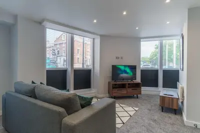 a living room with a couch and a flat screen tv at Spacious 1 Bedroom Apartment in Liverpool in Liverpool