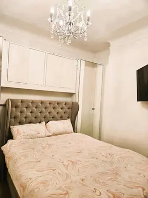 a bedroom with a large bed with a chandelier at Beautiful Residential Within Easy Reach of Town in Haydock