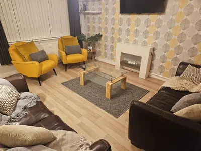 a living room with couches and chairs and a fireplace at Platt House in Wigan