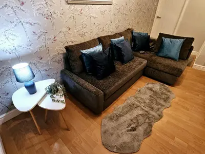 a living room with a couch and a table at Platt House in Wigan