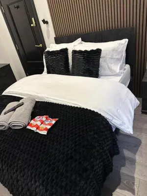 a bed with black and white sheets and pillows at 3M Luxury Living in Preston