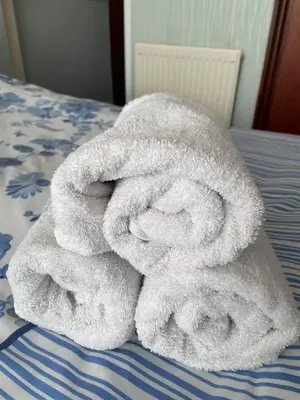 a pile of towels sitting on top of a bed at Roselea Hotel - St Chads in Blackpool