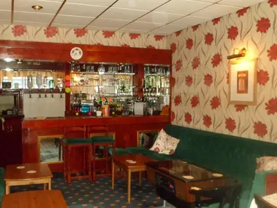 a bar in a restaurant with a green couch at Roselea Hotel - St Chads in Blackpool