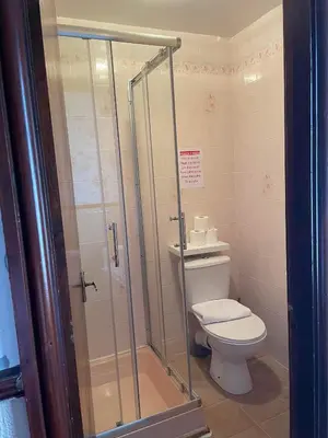a bathroom with a toilet and a glass shower at Roselea Hotel - St Chads in Blackpool