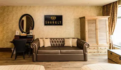 a living room with a leather couch and a mirror at The Shankly Hotel in Liverpool