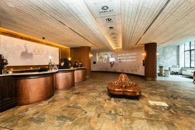 a lobby with a bar and a brown leather chair at The Shankly Hotel in Liverpool