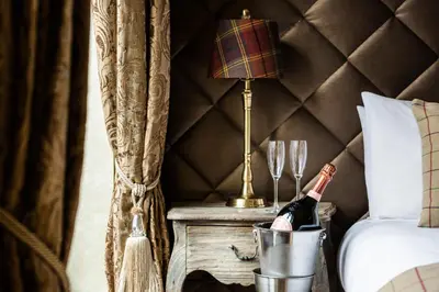 a bottle of champagne in a bucket next to a bed at The Shankly Hotel in Liverpool