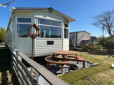 a picnic table in front of a tiny house at 148 Port Haverigg in Millom
