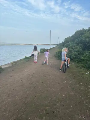 two girls and a woman on a bike on a path by the water at 148 Port Haverigg in Millom