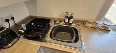 a microwave sitting on a kitchen counter with bottles of wine at Apartment 5 in Blackpool