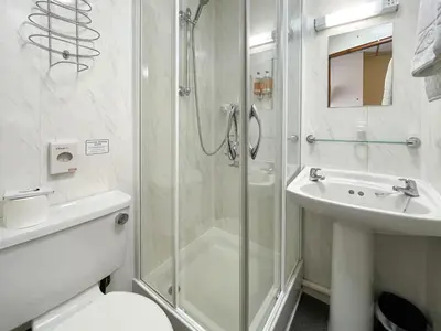 a bathroom with a shower and a toilet and a sink at The Auckland Hotel in Morecambe