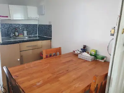 a kitchen with a wooden table and a kitchen with a sink at Second or Top Floor Studio Flat in Blackpool