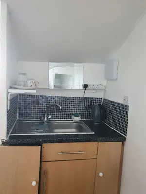 a kitchen counter with a sink and a mirror at Second or Top Floor Studio Flat in Blackpool