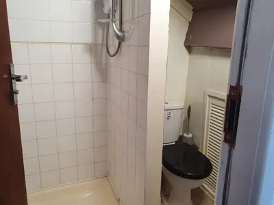a small bathroom with a toilet with a black seat at Second or Top Floor Studio Flat in Blackpool