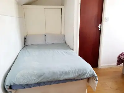 a small bed in a small room with a door at Second or Top Floor Studio Flat in Blackpool