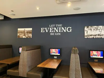 a restaurant with tables and chairs and a sign with let the everything be gin at Riverside Holiday Park in Banks
