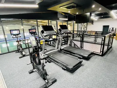 a gym with several treadmills and exercise bikes at Riverside Holiday Park in Banks
