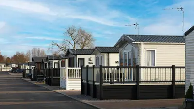 a row of houses behind a fence at Riverside Holiday Park in Banks