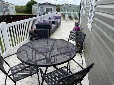 a patio with a table and chairs on a porch at The Dean's on the Lune in Heysham