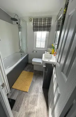 a bathroom with a tub and a sink and a toilet at The Dean's on the Lune in Heysham