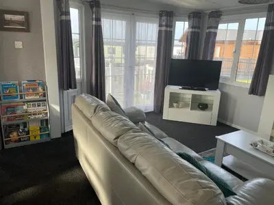 a living room with a couch and a flat screen tv at The Dean's on the Lune in Heysham
