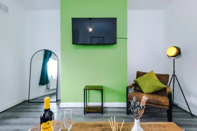 a living room with a couch and a tv on a wall at Acacia Lodge Retreat - Beautiful & Modern 3-BR with Wi-Fi by Parydise Properties in Shevington