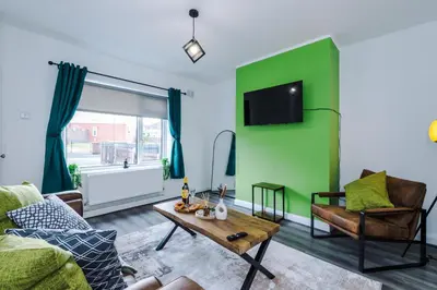 a living room with a green wall and a table at Acacia Lodge Retreat - Beautiful & Modern 3-BR with Wi-Fi by Parydise Properties in Shevington