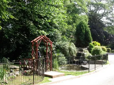 a playground in a park behind a fence at Briars Hall Hotel in Burscough