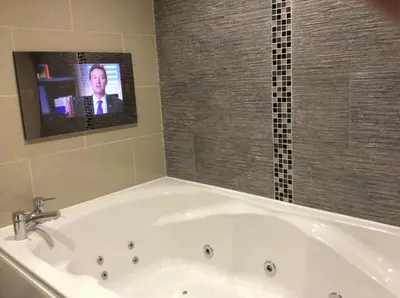 a bath tub with a tv in a bathroom at Briars Hall Hotel in Burscough