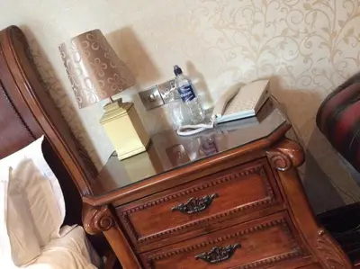 a bed with a nightstand with a telephone on it at Briars Hall Hotel in Burscough