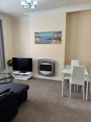 a living room with a tv and a table and chairs at Comfort, Convenience & Style in Preston