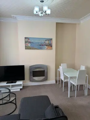 a living room with a television and a table with chairs at Comfort, Convenience & Style in Preston