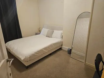 a small bedroom with a white bed and a mirror at Comfort, Convenience & Style in Preston