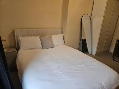 a bed with white sheets and pillows in a room at Comfort, Convenience & Style in Preston